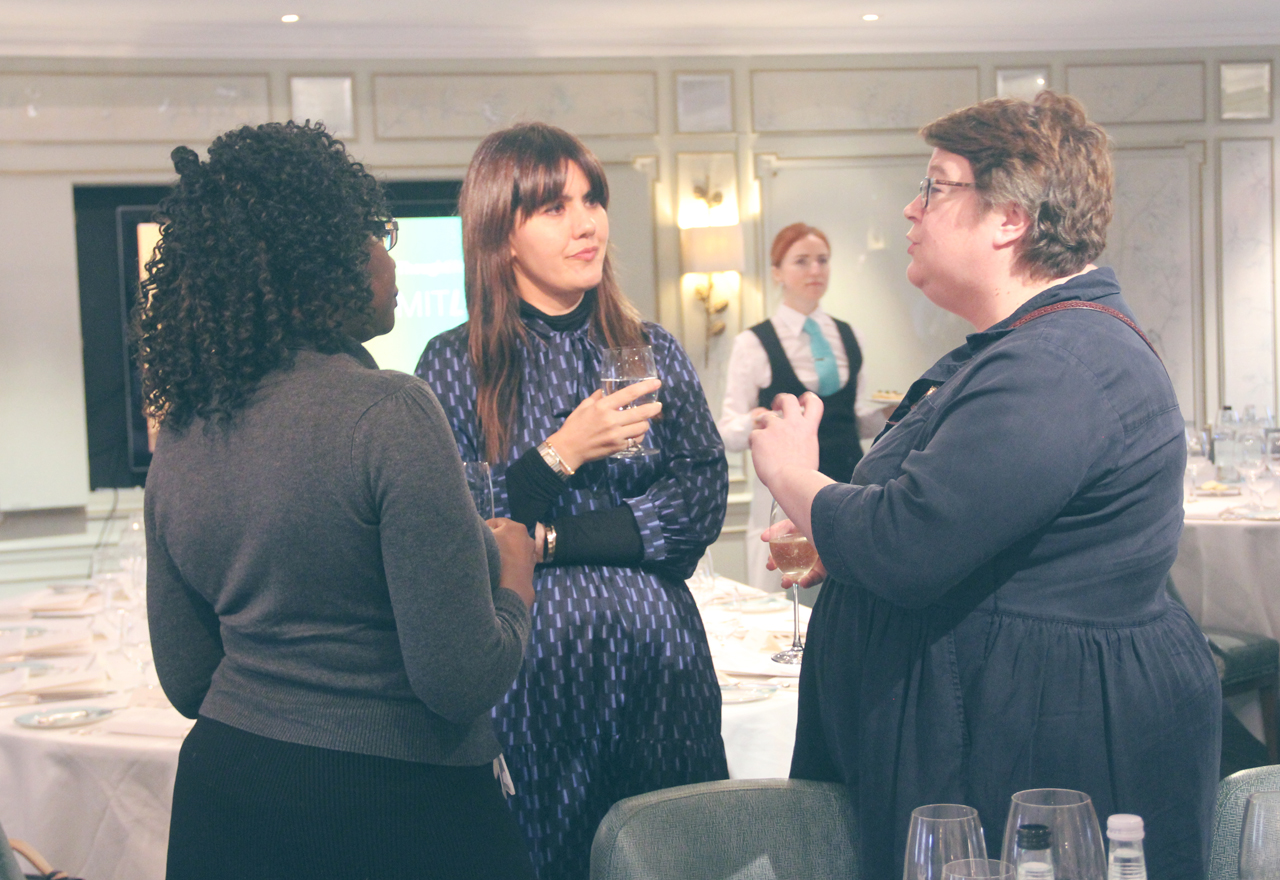 Three people deep in conversation at a Limitless event